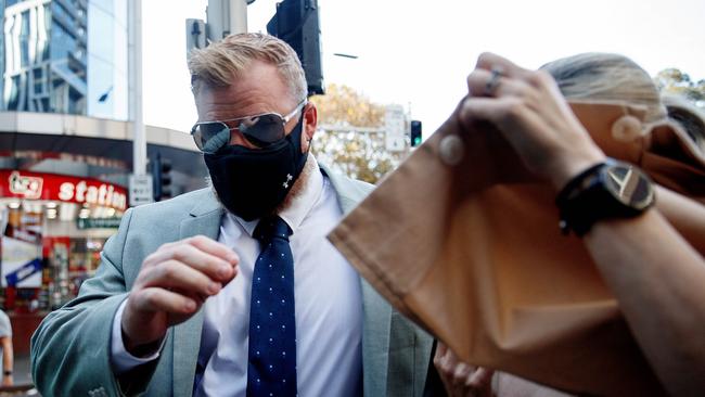 Holston and his supporters tried to avoid a press photographer as they arrived at court. Picture: NCA NewsWire / Nikki Short
