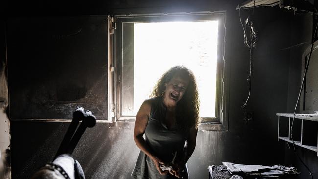 Kibbutz Nir Oz resident Hadas Kalderon whose children were taken hostage, and mother and niece killed breaks down in tears while looking through the burnt out home of her late mother Rina Sutzkever.