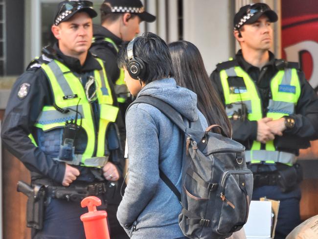 Pedestrians wearing headphones crossing Flinders street, Melbourne. Picture: Tony Gough