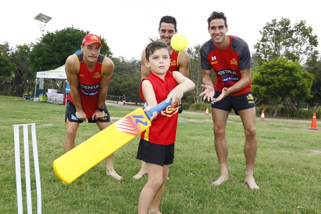 Mylo Eddington, 7, from the Gold Coast plays cricket with Gold Coast Suns players Ben Ainsworth, Brayden Fiorini and Ben King at Palm Beach. Picture: Tertius Pickard