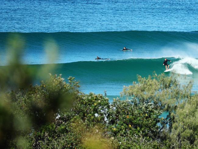 Surfers still manage to isolate from the crowds amongst the waves at Peregian Beach .  Photo Lachie Millard