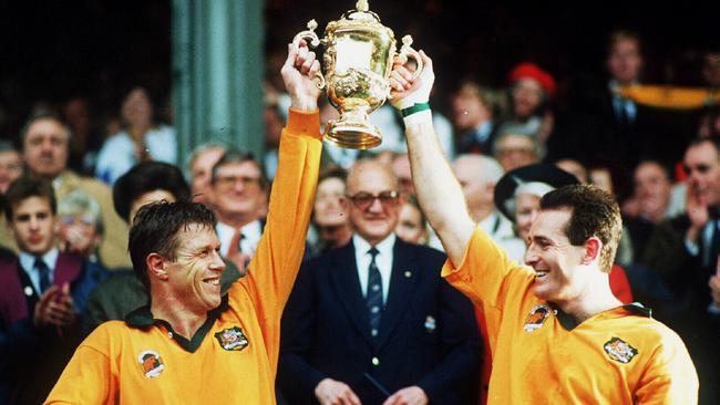 1991. Australian rugby union captain Nick Farr-Jones (L) and David Campese hold the Webb Ellis Rugby World Cup Trophy after the Wallabies win over England in the final.