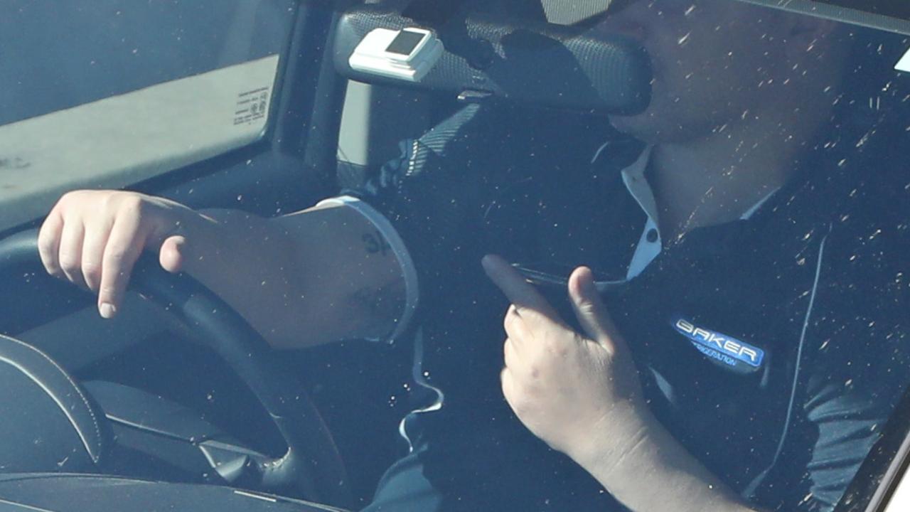 A driver on their phone while waiting at traffic lights. Picture: Damian Shaw