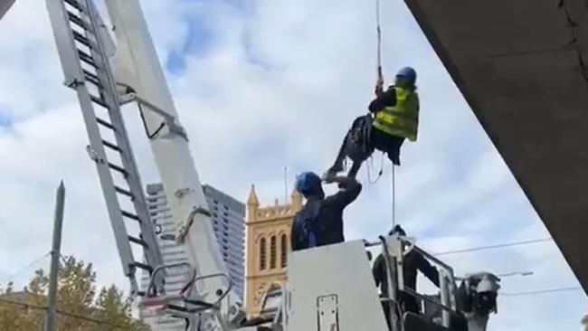 Extinction Rebellion protesters near Morphett Street Bridge on Wednesday, with one hanging from the bridge on a rope. Picture: Facebook