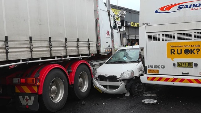 Southbound traffic on the Pacific Highway ground to a halt after a small passenger vehicle became trapped between a truck and a bus. Picture: Frank Redward