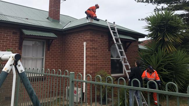 Detectives and SES rescue volunteers at the house where a 61-year-old woman was found dead. Picture: Ben Harvy