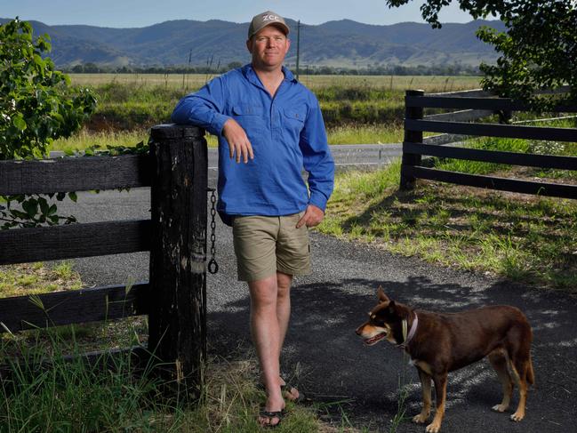 THE AUSTRALIAN. Mudgee electrician Daniel Stewart lives in Burrundulla, across the road from a previously planned solar farm, which was to be built on beautiful prime rural land right at the entrance to Mudgee. Daniel is one of a number of locals who successfully fought the proposal in the Land and Environment Court. PICTURED with his dog Millie at the gate to his property, with the land in question on the other side of the road behind. The development was part of the Central-West Orana renewable energy zone. 09/02/2024. Picture by Max Mason-Hubers