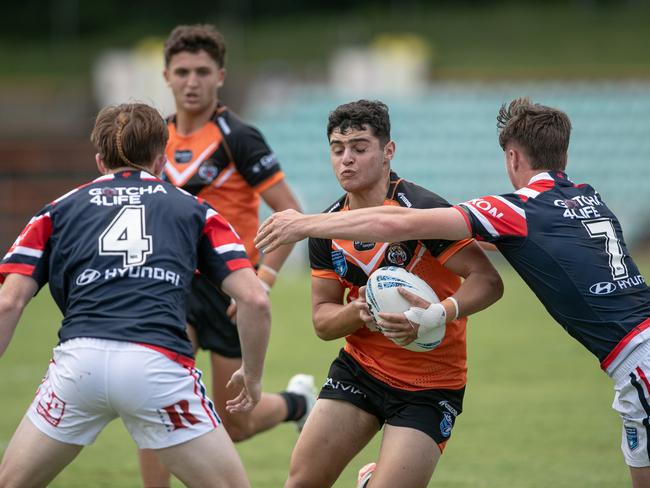 Michael Boustany is tackled by Roosters players Cohen Dittmann (left) and Lachlan Metcalfe. Picture: Julian Andrews