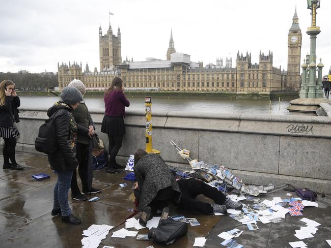 An injured woman is assisted on Westminster Bridge in London. Picture: Reuters