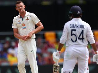 Australia's Josh Hazlewood (L) shares at India's batsman Shardul Thakur (R) on day three of the fourth cricket Test match between Australia and India at the Gabba in Brisbane on January 17, 2021. (Photo by Patrick HAMILTON / AFP) / --IMAGE RESTRICTED TO EDITORIAL USE - STRICTLY NO COMMERCIAL USE--