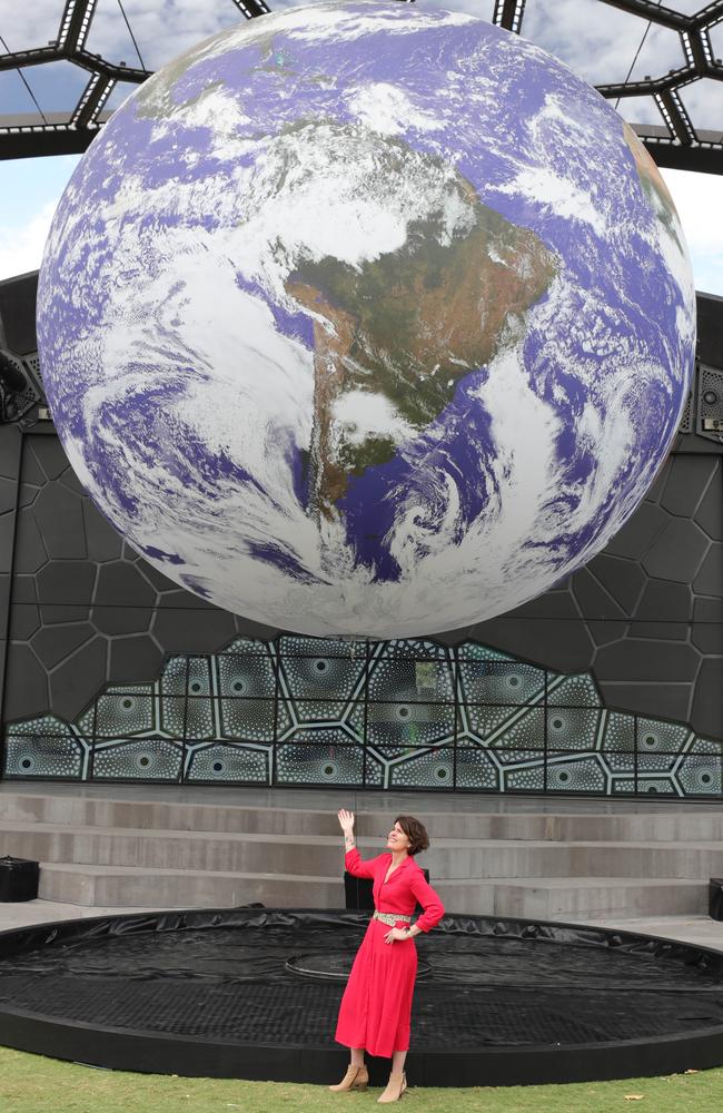 HOTA CEO Criena Gehrke next to a major earth installation, GAIA by Luke Jerram, which is suspended from HOTA’s Outdoor Stage. Picture: Glenn Hampson.