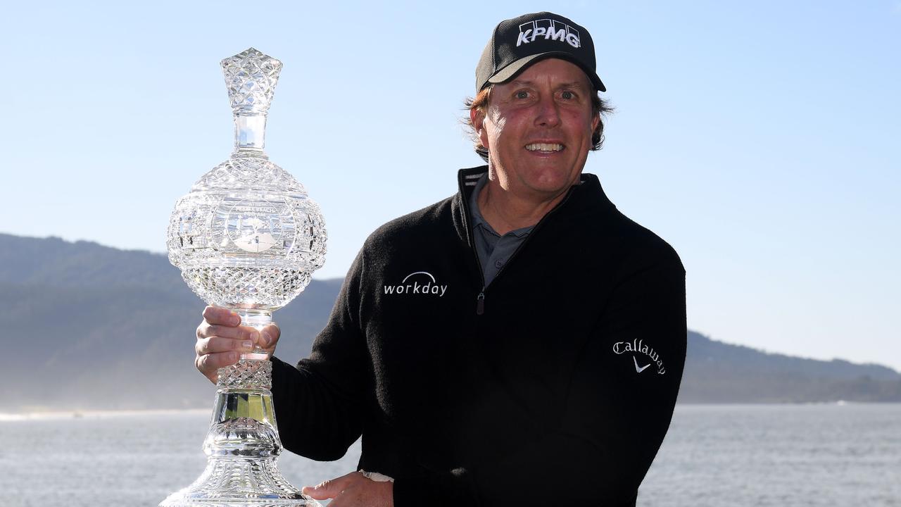 Phil Mickelson poses with the trophy after his victory at the Pebble Beach Pro-Am.
