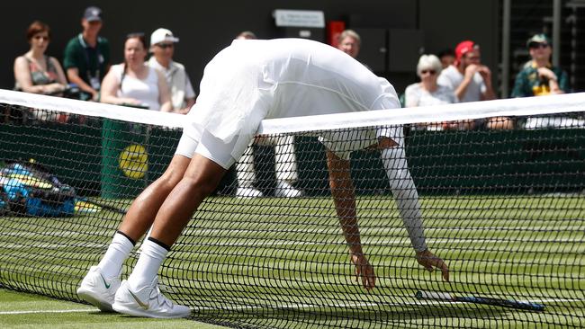 Australia’s Nick Kyrgios slumps over the net during his Wimbledon first round victory over Jordan Thompson. Picture: AFP