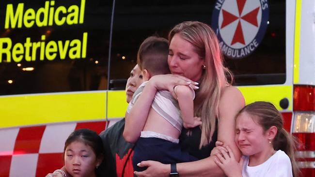 Mothers hold their families. Picture: David Gray / AFP)