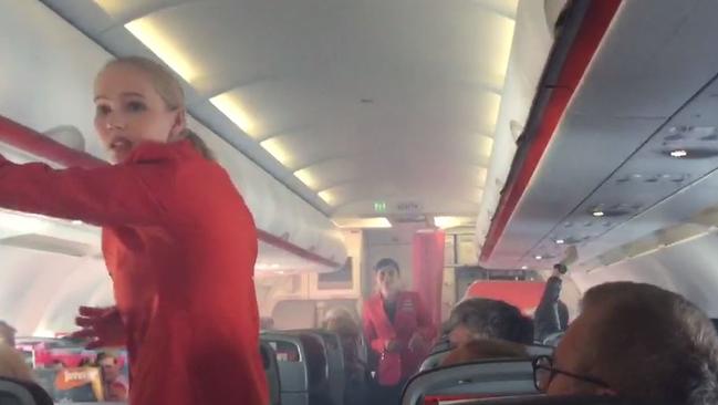 Cabin staff deal with the smoke on the Sydney to Cairns flight that was diverted to Brisbane.