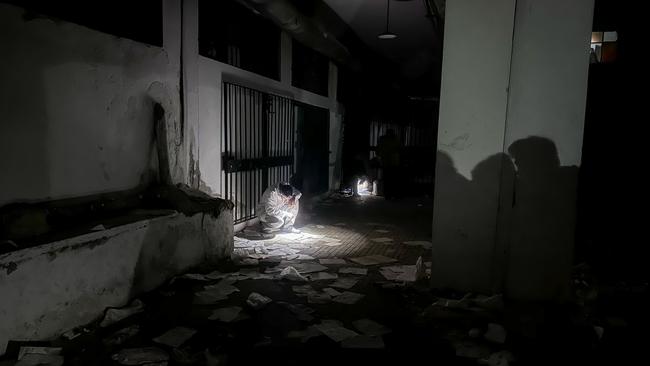 Rescue workers work by torchlight after power to the prison was turned off. (Photo by Bekir Kasim/Anadolu via Getty Images)