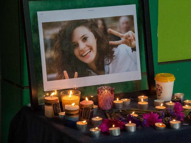 A candlelit table holding up a smiling photo of Aiia Maasarwe at a lunchtime memorial at La Trobe University. Picture: Jason Edwards