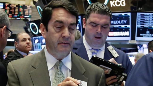 Mark Muller, foreground left, works with fellow traders on the floor of the New York Stock Exchange, Monday, Nov. 16, 2015. U.S. stocks are opening slightly higher as markets around the world are holding up better than many expected in the wake of the terrorist attacks in Paris. (AP Photo/Richard Drew)
