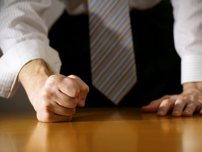 A DSLR photo of a businessman hitting the table with clenched fist. Can illustrate the concept of stress, disagreemnet, anger, etc. Istock