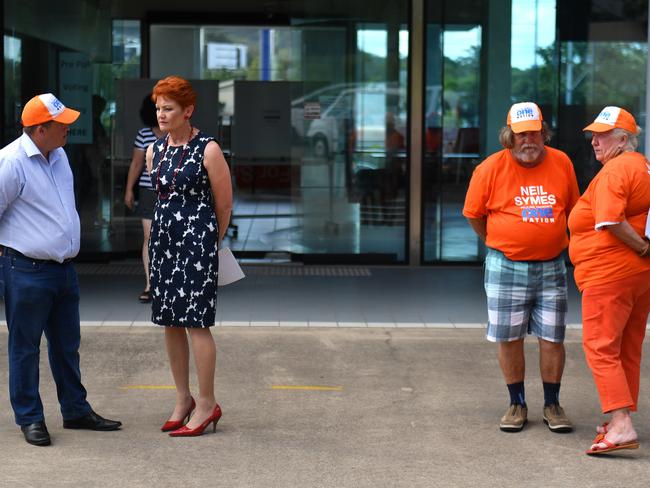 One Nation Leader Senator Pauline Hanson (second left) speaks with candidate Neil Symes (left) at a polling station in Masfield, south of Brisbane while campaigning for the Queensland election. Picture: Mick Tsikas/AAP