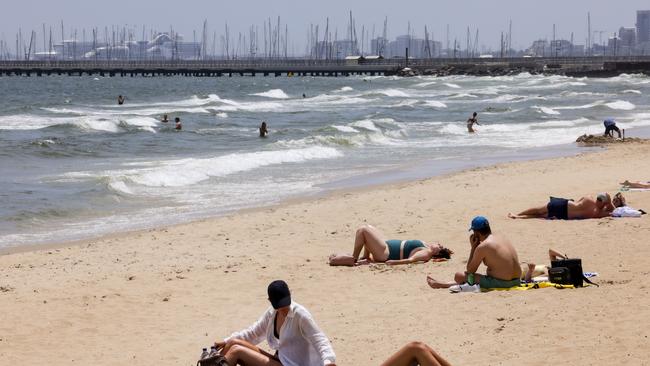 Beach goers sunned themselves at St Kilda on Monday - what may have been a safer option that swimming. Picture NCA NewsWire / Ian Currie