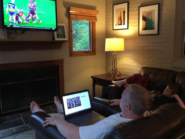 Matt Astill, the former Manly and Newtown Jets player now living in the US, pictured with his son Dylan 7, watching the resumed NRL season. Picture: Supplied