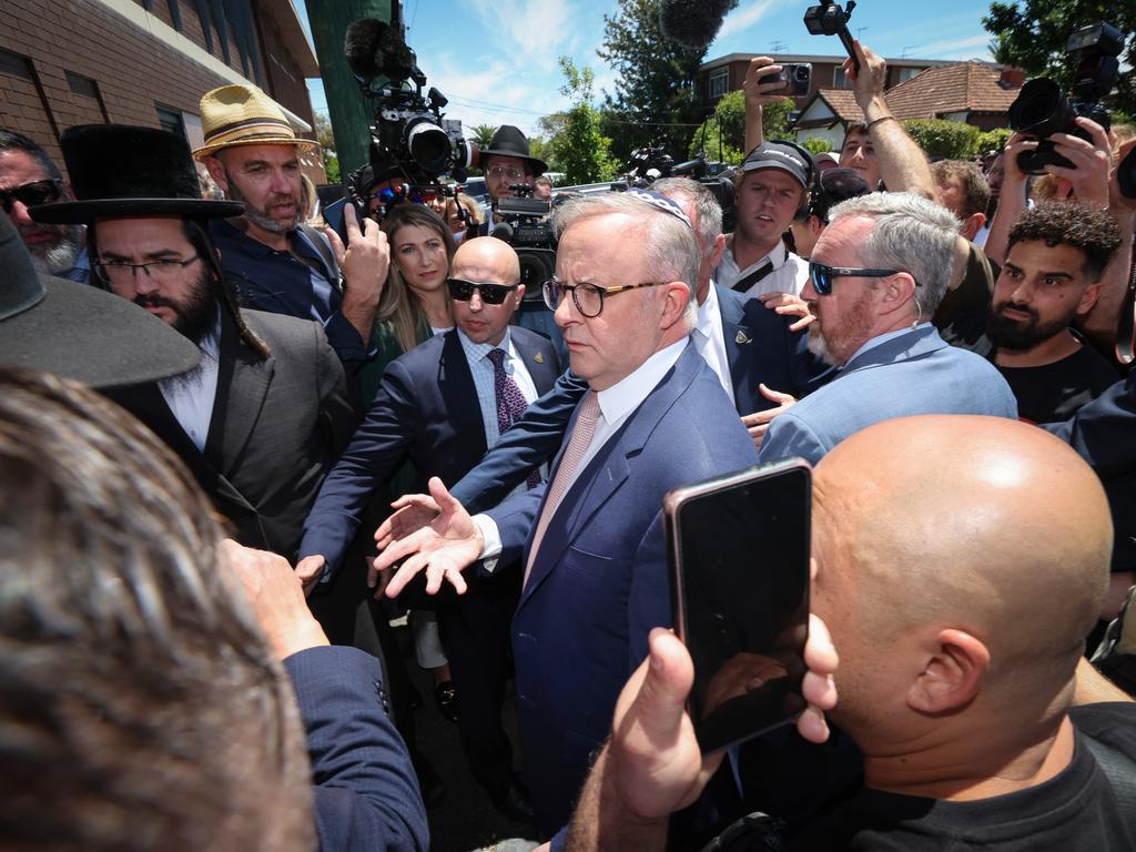 Prime Minister Anthony Albanese looks concerned at the crowd crush while protected by his security team leaving from a side door of the Synagogue after a meeting with community leaders. Picture: David Caird