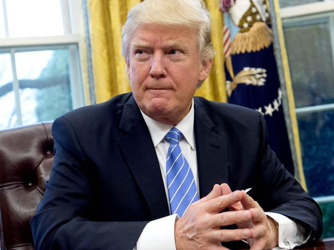 US President Donald Trump prepares to sign several executive orders in the Oval Office of the White House in Washington, DC, January 23, 2017. Trump on Monday signed three orders on withdrawing the US from the Trans-Pacific Partnership trade deal, freezing the hiring of federal workers and hitting foreign NGOs that help with abortion. / AFP PHOTO / SAUL LOEB