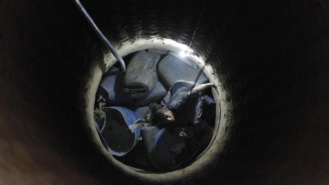 A Palestinian tunnel worker speaks to a colleague from inside a tunnel dug beneath the Gaza-Egypt border.