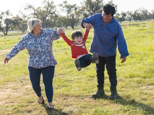 Memphis Francis with his grandparents Alex and Mark Facer. He has been stuck on their farm near Griffith after Queensland closed its border. Picture: Ginette Guidolin