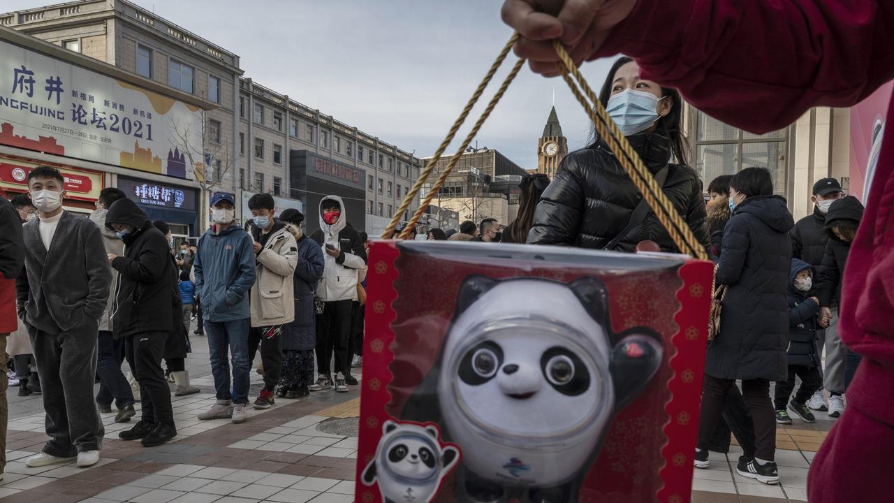 A man holds a toy of mascot Bing Dwen Dwen he just bought as people line up with hundreds of others to enter the official Beijing 2022 Winter Olympics flagship store to buy merchandise. Picture: Getty Images