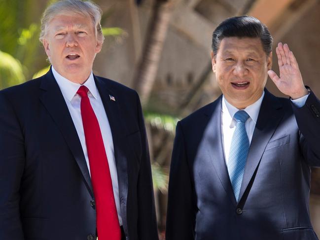 TOPSHOT - Chinese President Xi Jinping (R) waves to the press as he walks with US President Donald Trump at the Mar-a-Lago estate in West Palm Beach, Florida, April 7, 2017. / AFP PHOTO / JIM WATSON