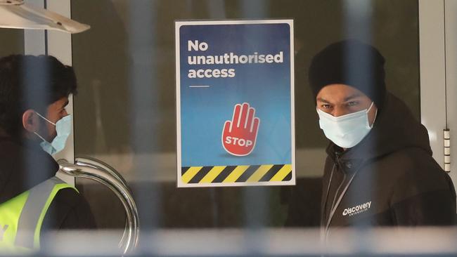 Police, security and NSW Health officers out the front of 16 to 18 Botany Street Junction – which has been quarantined with nine residents now having contracted Covid-19. Picture: John Grainger