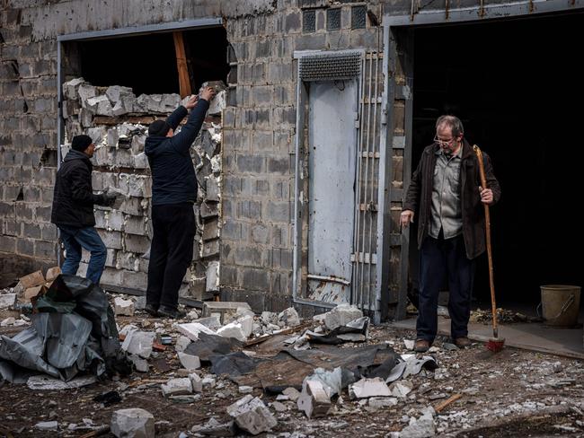 Residents try to strengthen the wall of a house damaged by recent shelling, on the outskirts of Kyiv. Picture: Dimitar Dilkoff / AFP)