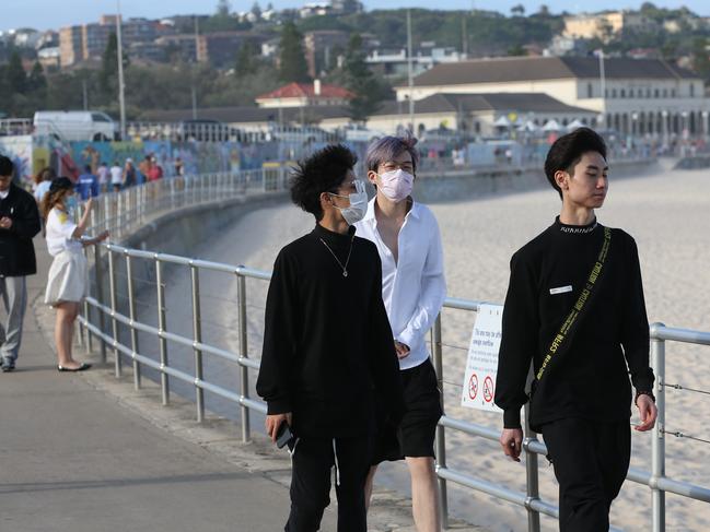 People walk along a now-empty Bondi Beach. Picture: Damian Shaw