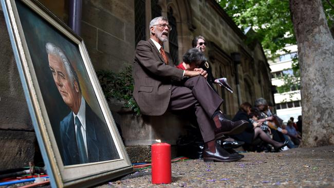 A portrait of Gough Whitlam with a candle sits across from the memorial service for the former Prime Minister outside of the Town Hall in Sydney on November 5, 2014. Picture: AAP