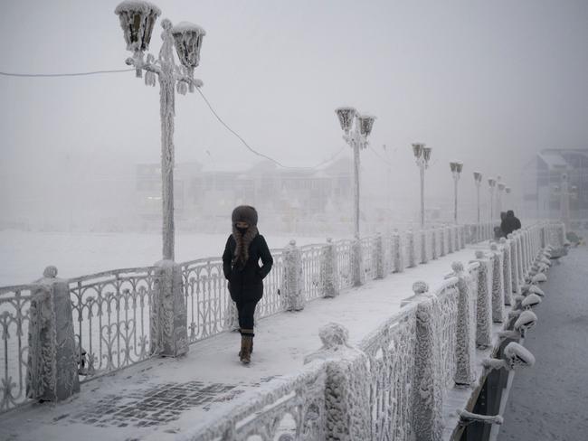 A woman walks over an ice-encrusted bridge in Yakutsk Village of Oymyakon.