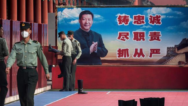 People's Liberation Army soldiers with a picture of Chinese President Xi Jinping next to the entrance to the Forbidden City in Beijing. Picture: AFP