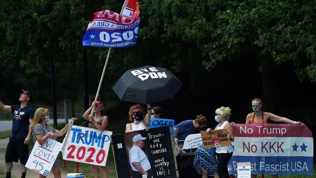 Protesters and supporters of US President Donald Trump's hold signs outside the Trump National Golf Club in Sterling, Virginia. Picture: AFP