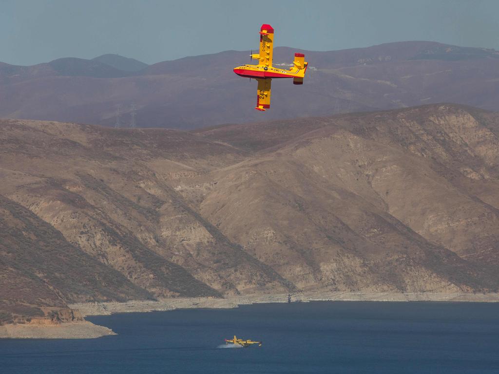 Aerial firefighting aircraft maneuver above Castaic Lake to pick up water for fighting the Hughes Fire in Castaic, a neighborhood of Los Angeles, California. Picture: AFP