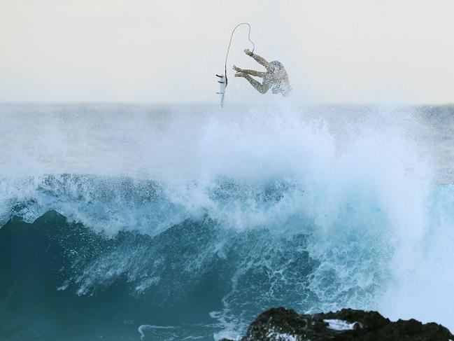 A surfer is seen at Snapper Rocks on the Gold Coast , Thursday February 21, 2019. Huge swells and high tides are set to pummelling south-east Queensland beaches over the coming days as Cyclone Oma tracks towards the Queensland coast. (AAP Image/Dave Hunt)