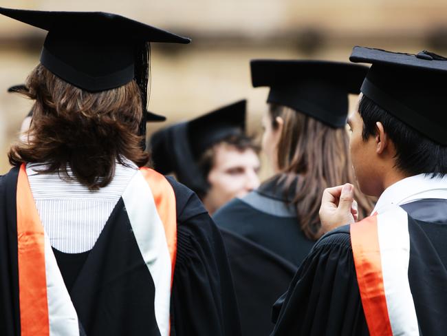 University students wearing their graduation mortar board hats and gowns for their graduation ceremony on campus at Sydney University in Sydney.