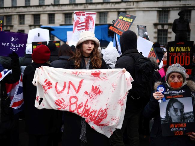 Demonstrators hold posters reading "UN Women, your silence is loud" along with a red paint-stained sheet reading "UNbelievable" during a rally in London. Picture: AFP