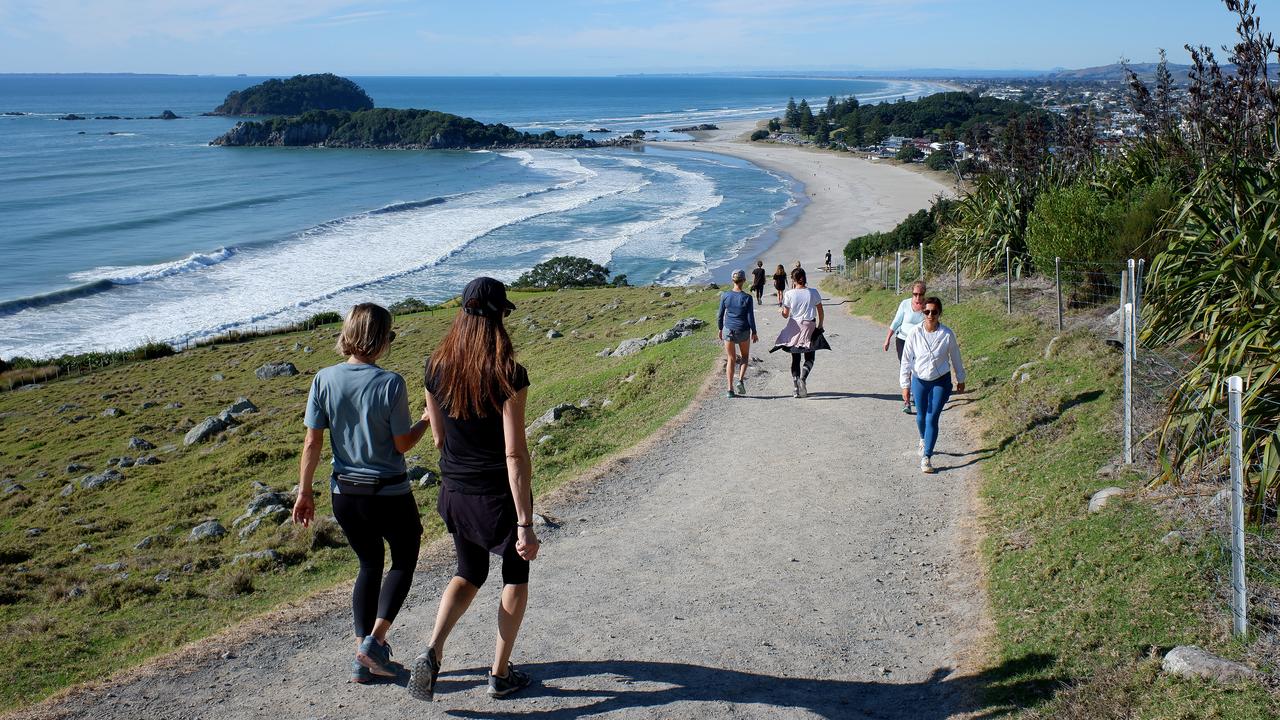 People walk up Mount Maunganui after it was reopened in NZ. Picture: Phil Walter/Getty Images