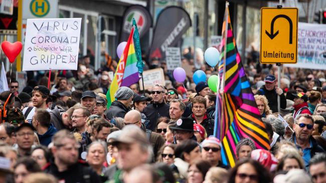 People walk through the city centre during a demonstration organised by the "Querdenken" movement to protest against the restrictions imposed by the government to fight the coronavirus pandemic, in Stuttgart, southern Germany. Picture: AFP