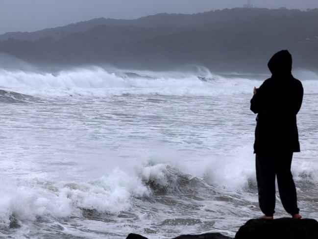 A resident watches massive waves stirred by TC Alfred. Picture: David Gray