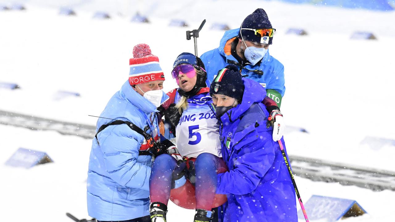 TOPSHOT - Norway's Ingrid Landmark Tandrevold is carried by teammates after crossing the finish line in the Biathlon Women's 10km Pursuit event, on February 13, 2022 at the Zhangjiakou National Biathlon Centre, during the Beijing 2022 Winter Olympic Games. (Photo by Tobias SCHWARZ / AFP)