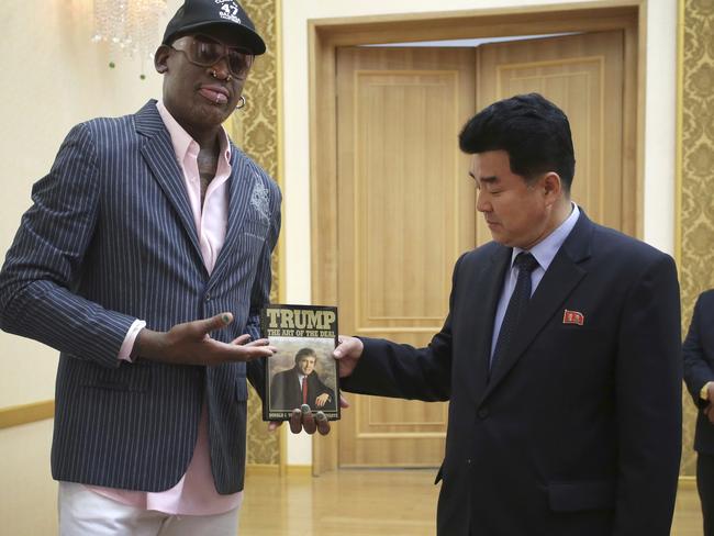Former NBA basketball star Dennis Rodman presents Donald Trump’s The Art of the Deal to North Korea's Sports Minister Kim Il-guk in Pyongyang. Picture: AP Photo/Kim Kwang Hyon