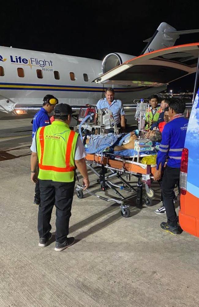 A critically ill Mark Richardson laying on a stretcher on the Bali tarmac. Picture: Supplied