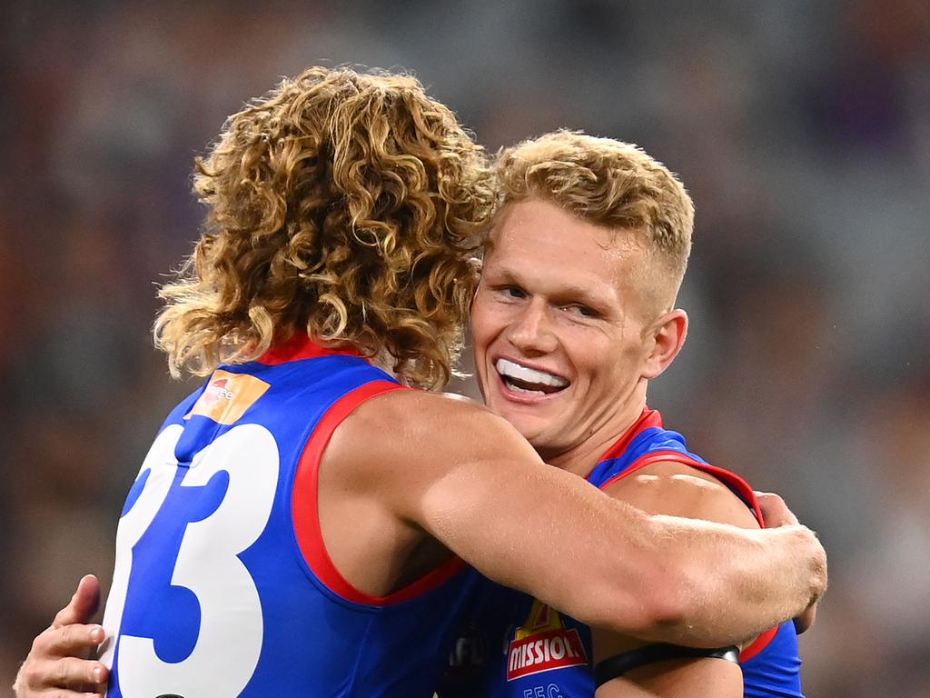 Aaron Naughton of the Bulldogs is congratulated by Adam Treloar.